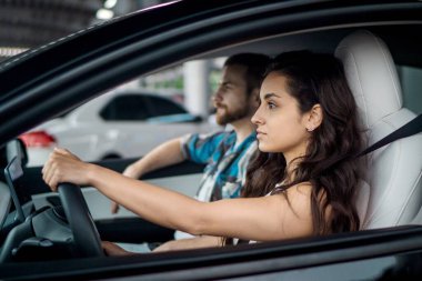 Şehirde genç bir çift araba kullanıyor. Yolculuğun tadını çıkarıyorum. Yan görüş. Seyahat macerası, mutlu yaz tatili konsepti