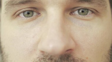Üzüntülü genç beyaz erkek kameraya bakıyor. Kırpılmış, kapat. İnsani duygular, vizyon kavramı. Yavaş çekim