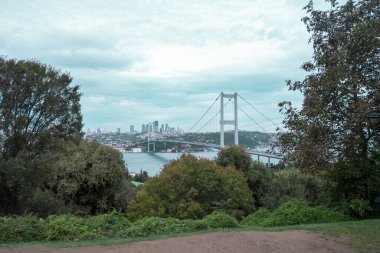 İstanbul 'un bulutlu bir manzarası olan Nakkastepe Parkı' ndan güzel Boğaz manzarası, ağaçlar arasında köprü, deniz manzarası, İstanbul 'da seyahat, Fatih Sultan Mehmet Köprüsü