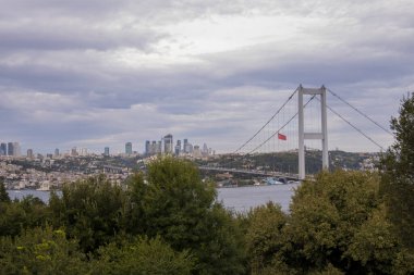 İstanbul Boğazı ve Nakkastepe Milli Bahçesi manzarası, Ağaçlar ve bulutlu hava, İstanbul turizm afişi, 15 Temmuz Şehitler Köprüsü, ulaşım fikri