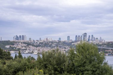 Nakkastepe Milli Bahçesi, Ağaçlar ve Bulutlu Hava, İstanbul turizm afişi, İstanbul manzarası, gökdelen ve binalardan geniş açılı İstanbul Boğazı ve kent manzarası