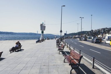 Arnavutköy 'de halk ve deniz feneri, bankta oturan ve dinlenen insanlar, manzaralı yol, İstanbul' dan gelen şehir manzarası: Arnavutkoy, İstanbul, Türkiye - 15 Eylül 2022