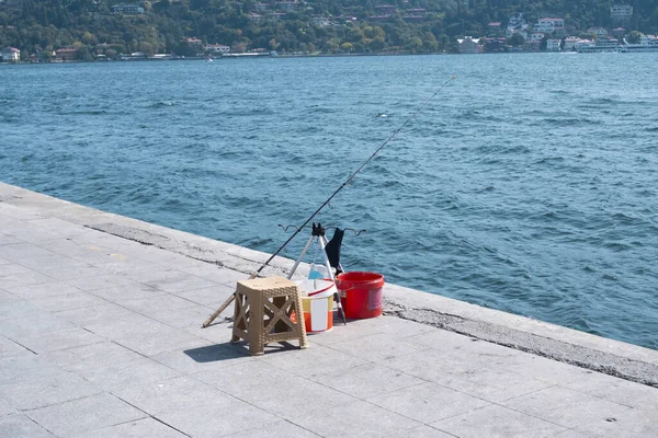 stock image Fishing rod and equipment on the shore of the Bosphorus, no people, sunny day, angling concept, Arnavutkoy seaside, Turkey tourism