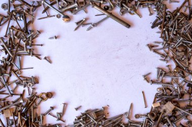 Paslı çivi yığını ve fotokopi alanı olan küçük donanım fındıkları, beyaz arka plana saçılmış oksitlenmiş çivi ve perçin yığınları, boş alan