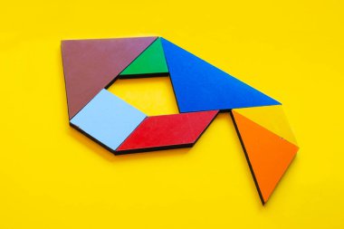 Tangram oyuncağıyla yapılmış renkli 9 numara, sarı arka planda izole edilmiş 9 numaralı renkli tangram, çocuklar için oyun fikri, çocuklar için saymayı öğretmek, bulmaca oyuncağı, dokuzuncu numaranın üst görünümü