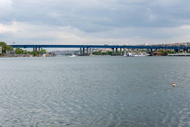 Bulutlu gökyüzü ile uzun mavi köprü, deniz ve gemilerle manzara, güzel manzara, kasvetli ve kasvetli gökyüzü