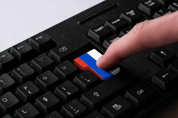 按下带有俄罗斯国旗的进入按钮 表示俄罗斯的网络攻击 学习俄语的隐喻 关闭黑色键盘 选择性聚焦 — 图库照片