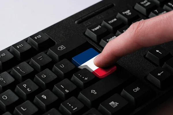 按下带有法国国旗的进入按钮 代表了法国的网络攻击 学习法语的隐喻 关闭黑色键盘 选择性聚焦 — 图库照片