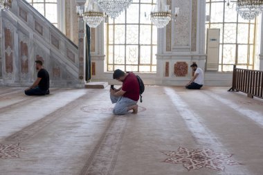 Ortakoy Camii 'nde namaz kılan Müslümanların fotoğrafını çeken turist, Buyuk Mecidiye Camii, inanç ve inanç fikri: Ortakoy Camii, İstanbul, Türkiye