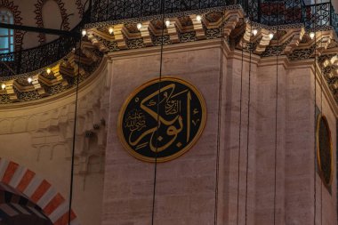 Süleyman Camii 'nin içi, camide yeşil plaka üzerine İslami metin, geçmişe dönük altın avize, İslam ve din kavramına yakın, seçici odak: Süleyman Camii, İstanbul, Türkiye