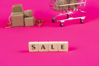 Arka planda karton kutu alışveriş arabası, indirim ve özel teklif konsepti, e-ticaret sancak fikri, tramvay ve mektuplar, satın alma veya satma fikri, yer kopyalama