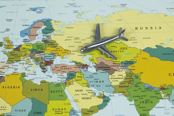 Miniature Airliner leaving from Russia, plane on the map going to Europe, air transportation concept, international transportation