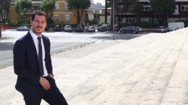 Yakışıklı iş adamı akıllı telefonuyla bir iş görüşmesi yapıyor. Genç işadamı akıllı telefonuyla onun hakkında konuşurken yürüyor..