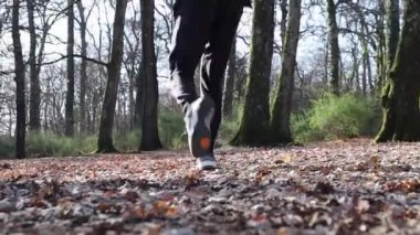 Güzel genç adam ormanda koşuyor. Adam İtalya 'daki parkta antrenman yapıyor. Doğa ile temasta spor ve refah kavramı.