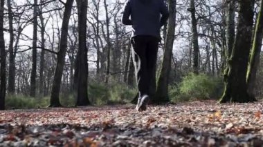 Güzel genç adam ormanda koşuyor. Adam İtalya 'daki parkta antrenman yapıyor. Doğa ile temasta spor ve refah kavramı.