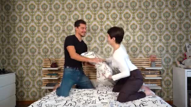 Молода Щаслива Закохана Пара Бореться Подушкою Ліжку Вдома Пара Концепція — стокове відео