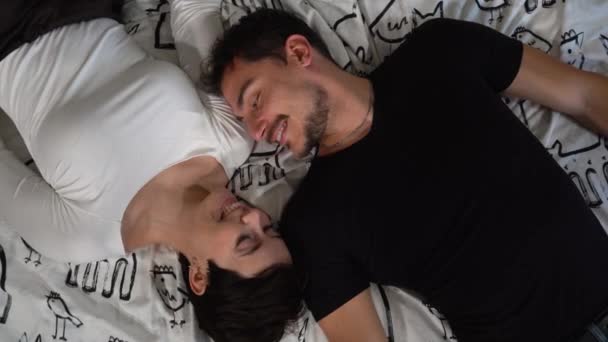 恋に落ちた若い夫婦がベッドの上に横たわっている 美しいカップルの交換の愛撫とキス 愛の概念 — ストック動画