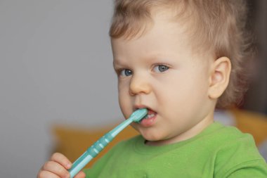 Cute baby 2 years old brushes his teeth with a toothbrush. The concept of oral hygiene and healthy teeth from infancy.