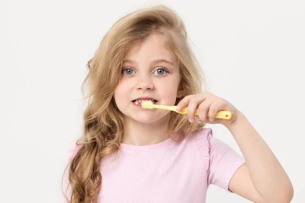 Ένα Χαριτωμένο Ξανθό Κορίτσι Λευκό Φόντο Κρατάει Μια Οδοντόβουρτσα Κοντά — Φωτογραφία Αρχείου