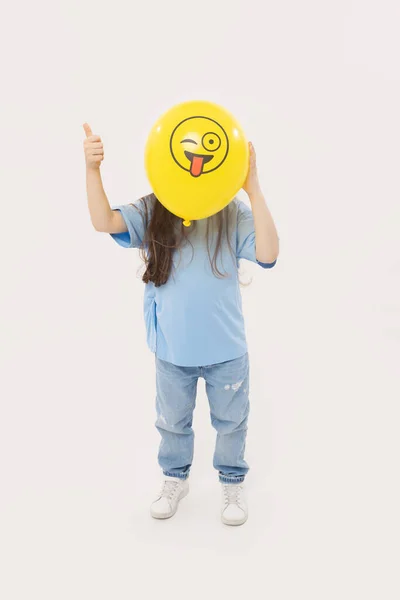 Een Meisje Verbergt Zijn Gezicht Achter Een Gele Knipperende Emoticon — Stockfoto