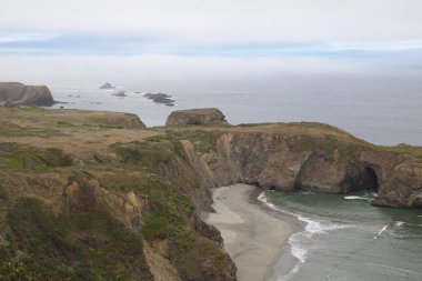 San Francisco 'nun kuzeyinden Pasifik Okyanusu manzarası. Büyük kayalar dağılmış ve havada bir sis var.