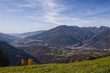 Dağlardaki dağ çayırları, mavi bulutlu gökyüzü.