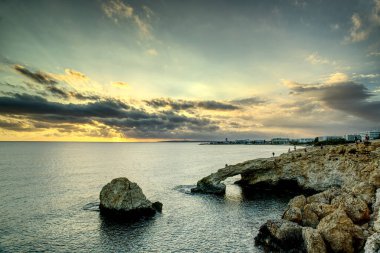 Kıbrıs Rum Kesimi 'nin kayalık sahillerinde bulutlu gökyüzü ile muhteşem bir yaz günü.