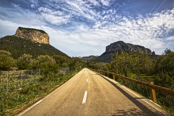 Yazın bulutlu gökyüzünde, orman dağlarında yol