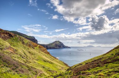 Madeira, Ponta de So Loureno 'daki güzel kayalar, bir yaz günü mavi bulutlu gökyüzü ve adanın kuzey ve güney kesimlerinde panoramik manzaralı görkemli bir manzara.