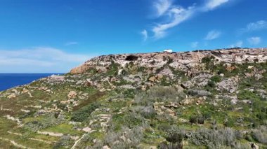 Tal-Mixta Mağarası. etkileyici mağara denizin 100 metre yukarısında, güneşli bir günde mavi bulutlu gökyüzü ile yükseliyor. Mağaranın etrafında uçuşan.