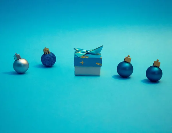 Noel Hediyesi Mavi Kutu Arka Planda Dekoratif Renkli Toplar Düz — Stok fotoğraf