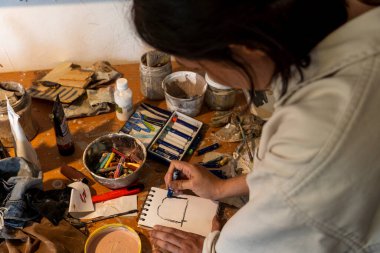 Sanat atölyesi, dağınık nesneler, fırçalar, renk paleti, karışık boyalar düzensiz kadın sanatçı Meksika Latin Amerika