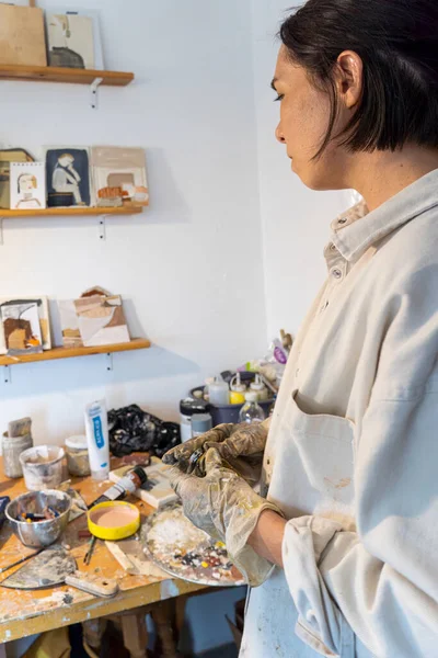 young latin woman, in her own painting and sculpture studio, creates paintings with different artistic techniques mexico latin america