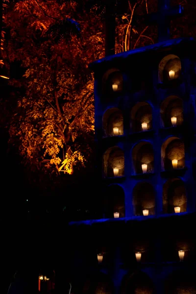 cemetery candles, monument with niches with candles in each space, night day of the dead mexico latin america