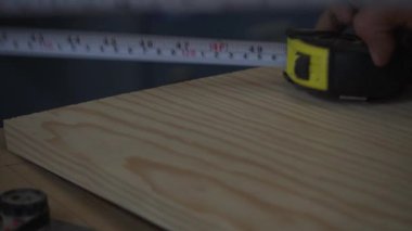 Ahşap ayrıntıları ruletle ölçen ve kalemle iz bırakan işçilere yakın çekim.