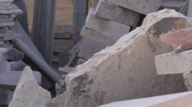 Pembe ve gri taş ocağı taşı, farklı şekil ve boyutlarda, küreler, kareler, küpler. Taş işledikleri mermer dükkânı.