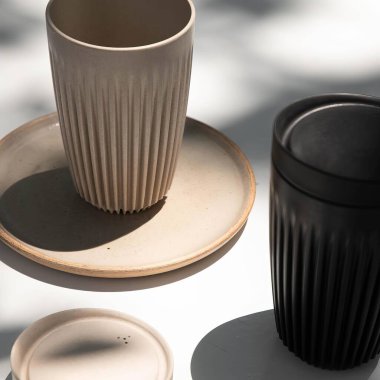 Dikey çizgileri olan seramik gözlükler seramik plaka beyaz arkaplan ve doğal ışık çizgilerini yazarlar.