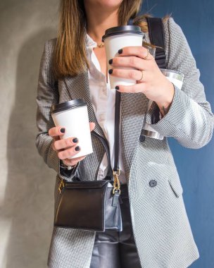 Gününü tamamlamak için iki kahvesi olan modern Latin kadın gündelik Latin Amerika kıyafetleriyle işe gidiyor.