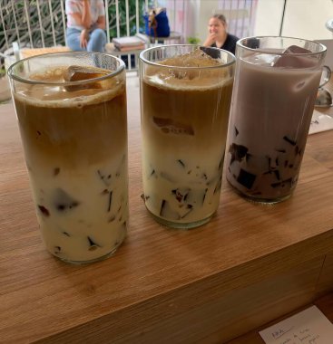 Soğuk latte, ahşap masa üzerinde koyu arka plan, yaz için buzlu kahve.