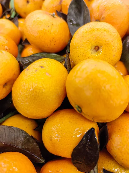 Selective focus of pile of colorful orange fruits in the market, background for copy space ads.