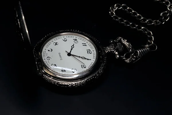 old brass pocket watch on dark background