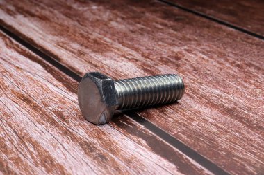 a single screw on a wooden table