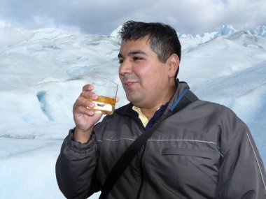 Tek başına yürüyen ve buzlu viski içen bir adam Perito Moreno Buzul Arjantin 'den