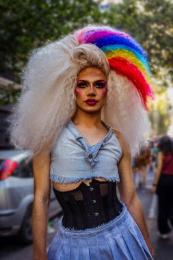Şeref gününü kutlamak için zarif giyimli drag queen gökkuşağı boyalı saç telleriyle