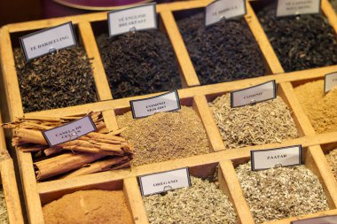 Ahşap çekmeceler dolusu tarçın baharatları ve baharatlarla etiketlenmiş posterler.