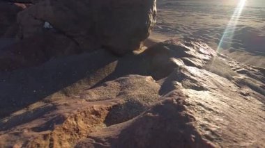 Piedras coladas, Las Grutas, Rio Negro, Arjantin 'deki ıssız bir sahildeki kayaların videosu. Yaz güneşiyle aydınlanıyor. Mercek, rüzgar ve kum erozyonuyla..