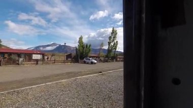 La Trochita treninin penceresinden çekilen el kamerası görüntüsü, tarihi Nahuel Pan istasyonuna yaklaşırken manzarayı yakalıyor..