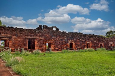 Büyüleyici bir zıtlık: Bulutlu gökyüzü San Ignacio Mini Misiones 'un tarihini geliştirir. Doğal ışık yıkıntıları sükunetle yıkar..