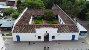 Casa Histrica de Tucumn 'un sömürge cephesinde insansız hava aracı uçuşu. Pencereleri, bayrakları, kalkanları ve iç bahçelerindeki yemyeşil bitki örtüsü..