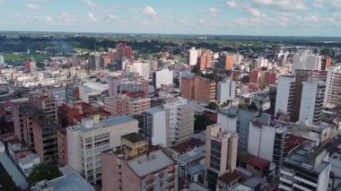 San Miguel de Tucumn 'un göz kamaştırıcı hava manzarası, binaların ufuk çizgisi ve arka planda bulutlu görkemli dağlar. Kentsel ve doğal manzaranın büyüklüğü.